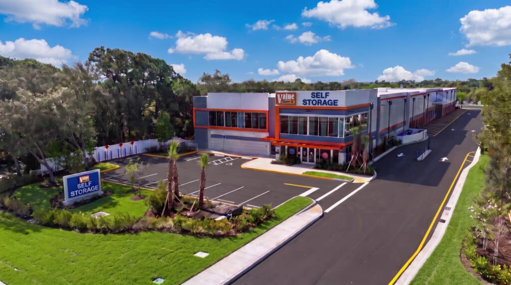 Aerial view of Value Store It self-storage facility with orange and white branding, parking lot, and surrounding landscaping.