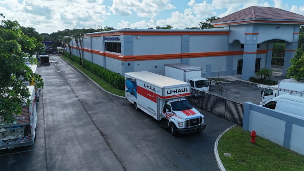 U-Haul moving truck parked outside blue and orange self-storage facility building