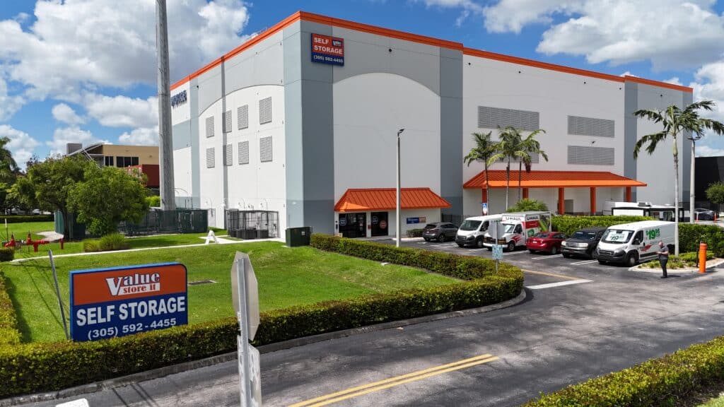 Value Store It self-storage facility exterior with orange trim and entrance canopy, parking lot visible.